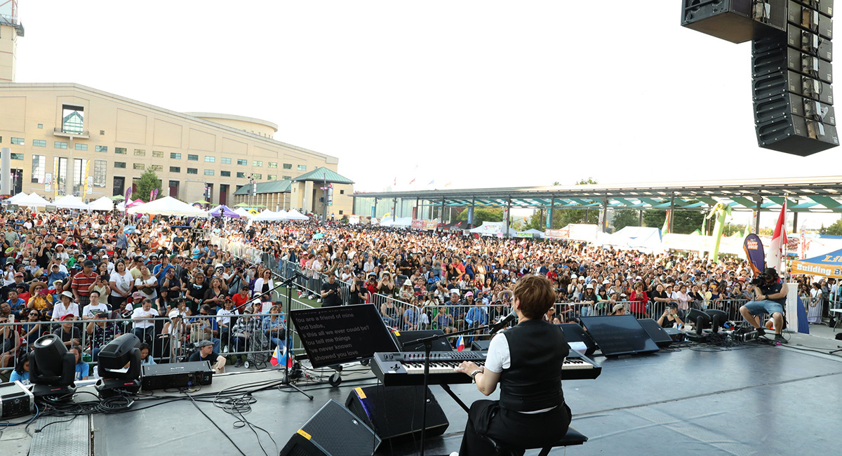 A musician playing a keyboard on stage.