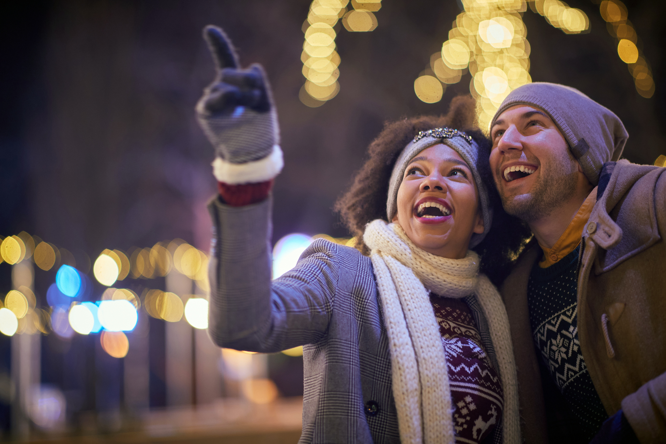couple outdoors on winter night pointing at something