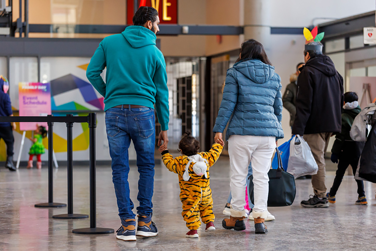 A family with young child walking through the Living Arts Centre
