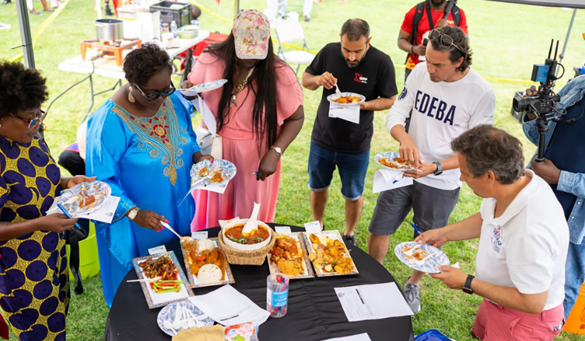 A group of people eating at the Jollof Fest
