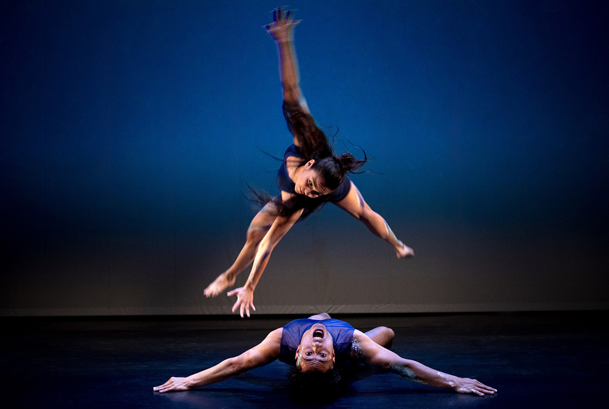 Dancers on stage in front of blue background