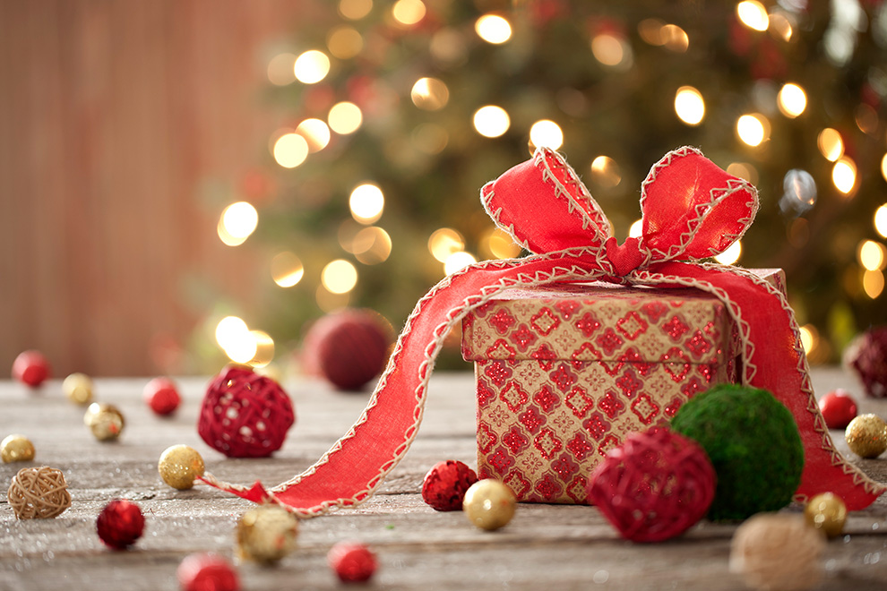 A gift wrapped in red wrapping paper with a red bow.
