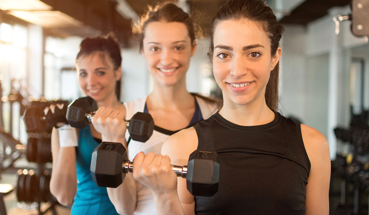 A group of teenage girls holding weights.