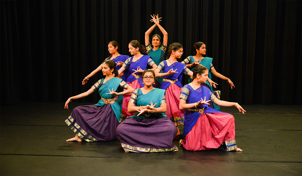 Sampradaya Dance Academy dancers posing on stage.