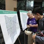 Residents reading information board at City Hall