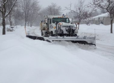Snow plow clearing a snow covered street
