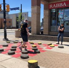 People playing life sized checkers game during 2019 tactical urbanism event