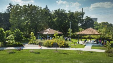 Photo of a park with expansive green space, waling trails and multiple covered picnic shelters for families to enjoy.