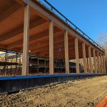 Construction site of a large wooden structure with clear skies.