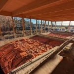 Interior view of a construction site with wooden beams and orange tarps.