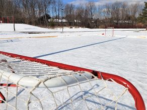 Red and white hockey net at natural ice rink