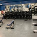 A row of dumbbells and benches in a fitness centre
