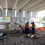 Construction workers working on an inside pool.