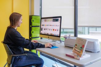 Girl sitting at desk using a desktop computer