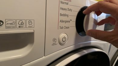 Someone turning the knob on an ENERGY STAR washer