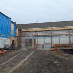 The exterior of the Carmen Corbasson Community Centre with exposed walls and ramps made of lumber leading up to a platform.