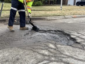 Person repairing pothole on a residential street. 