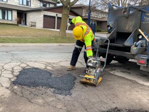 City staff person fixing a pothole on a residential street in Mississauga