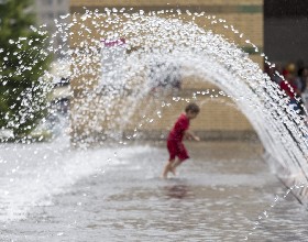 A child running through a water fountain.