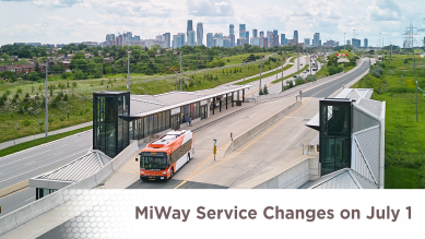 A bus driving on the City's transit terminal with the City's skyline in the back