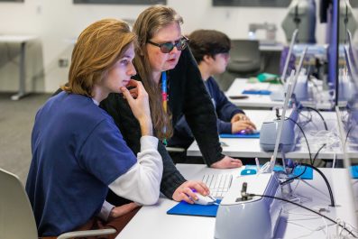 Two people looking at a computer scree at the LIirary.