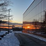 The sunrise is reflected in the exterior glazing.