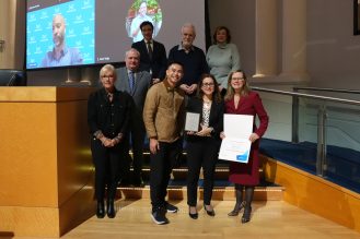 A group of people presenting an award to a recipient.