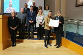A group of people presenting an award to a recipient.