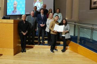 A group of people presenting an award to a recipient.