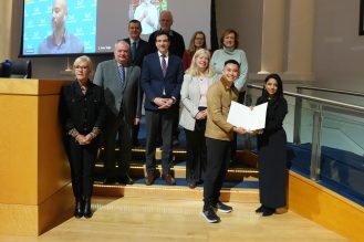 A group of people presenting an award to a recipient.