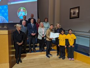 A group of people presenting an award to a recipient.