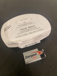 A fire alarm with a new battery ready to go in.