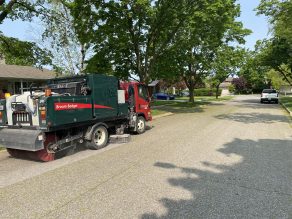 Street sweeper clearing debris along curb in Mississauga. 