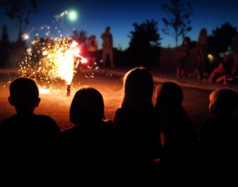 Kids Watching Fireworks on the street at a safe distance away.