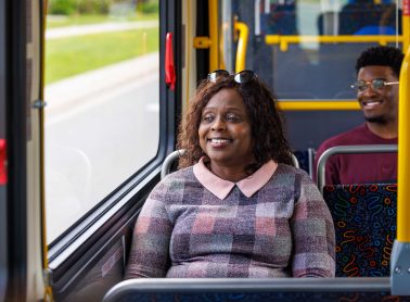 A lady on a bus looking out the window.