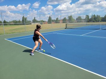 A person in tennis attire swinging a tennis racquet.