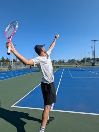 Someone playing tennis getting ready to serve the ball