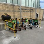 E-bikes and e-scooters parked within a yellow-framed parking structure