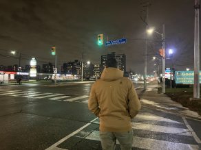 Person walking across crosswalk at night.