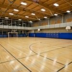 Indoor gym with basketball hoops, a soccer net and painted lines on the floor