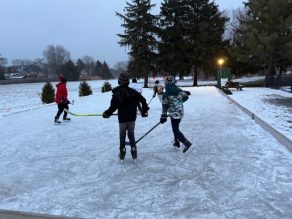 Picture of people playing hockey in a natural ice rink.