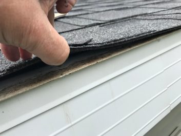 Checking a roof shingle that has come loose