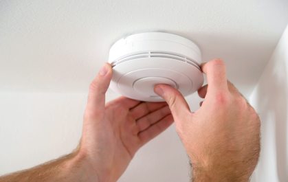 Person installing smoke alarm