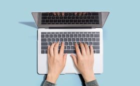 Photo of hands typing on laptop