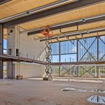 Construction worker on a boom inside the South Common Community Centre