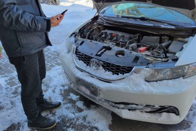 Full view of a person standing beside car with hood open