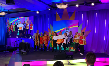 A group of people on stage with a big cheque