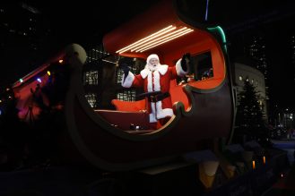 Santa Claus in his carriage waving at the crowd during the Santa Claus parade.