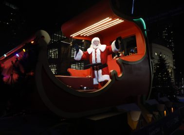 Santa Claus in his carriage waving at the crowd during the Santa Claus parade.