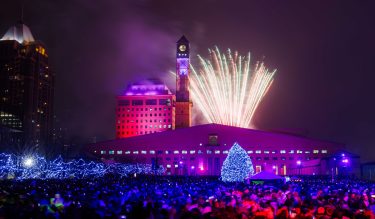 Fireworks being set off at Mississauga City Hall with crowd of people watching.